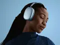 En kvinna med slutna ögon njuter av ljudet från sina ljusblå AirPods Pro Max 2.