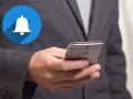 En person håller en smartphone med en notiscenter-ikon för iPhone.