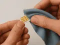 Händer som försiktigt putsar ett SIM-kort med en blå trasa. Enkel guide för hur man får ut simkortet.