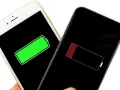 Två iPhones visar batteristatus: en fulladdad (grön) och en nästan urladdad (röd). Jämför iPhone 13 batterikapacitet.