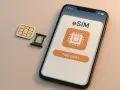 En telefon visar hur fungerar esim med en knapp för att lägga till. Bredvid ligger ett traditionellt SIM-kort och dess hållare.
