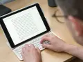 Person skriver på ett iPad-tangentbord. En text om "Zoku Round Pop Molds" visas på skärmen, vilket tyder på ett iPad-tangentbordstest.
