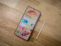Samsung-telefon med stylus och simkort. En skärm visar "Good afternoon" och väder.