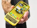 En gul iPhone med ett utskjutbart tangentbord. Knappljudet på iPhone hörs när man skriver.
