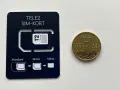 Ett Tele2 SIM-kort med utbrytbara delar för olika storlekar. Bredvid ligger en femkronorsmynt. Frågan om man kan ha två simkort med samma nummer är relevant för att hantera flera enheter.