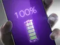 En hand håller en telefon med 100% laddning och en batteriikon. Perfekt samsung batteritid för en lång dag.