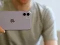 En person håller upp en lila iPhone 11. Man ser tydligt den dubbla iphone 11 kameran på baksidan.
