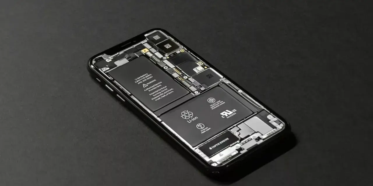 En öppen iPhone med synligt batteri och komponenter. För att spara batteri iPhone, se till att den är i gott skick.