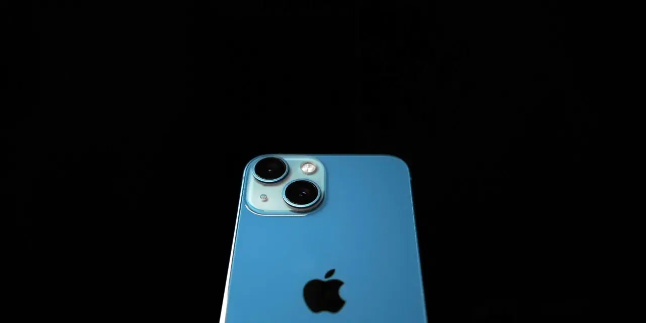 Blå iPhone med dubbla kameror och Apple-logga. Denna apple a16-enhet är redo att fånga dina minnen.