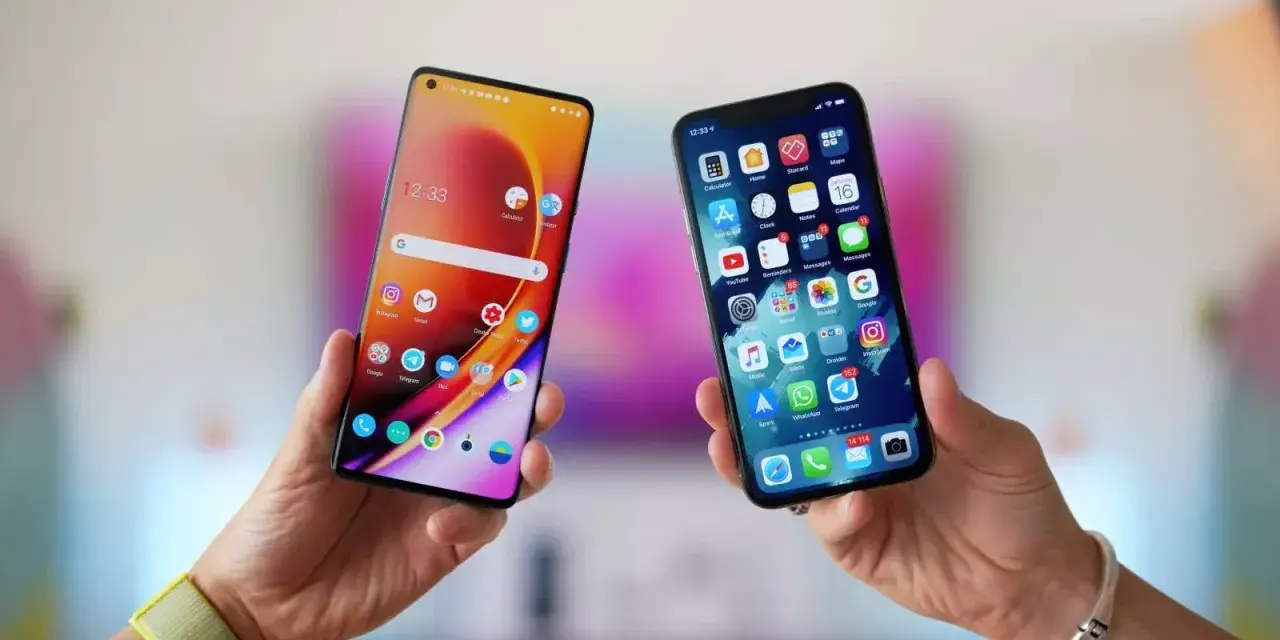 Två händer håller upp varsin smartphone. Den ena visar en Android-telefon, den andra en iPhone. Kanske dags att flytta till iOS?