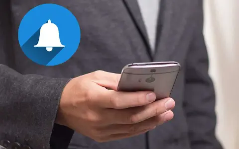 En person håller en smartphone med en notiscenter-ikon för iPhone.