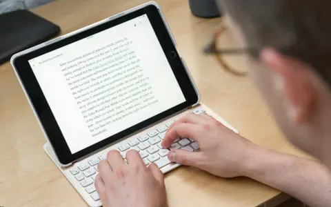 Person skriver på ett iPad-tangentbord. En text om "Zoku Round Pop Molds" visas på skärmen, vilket tyder på ett iPad-tangentbordstest.