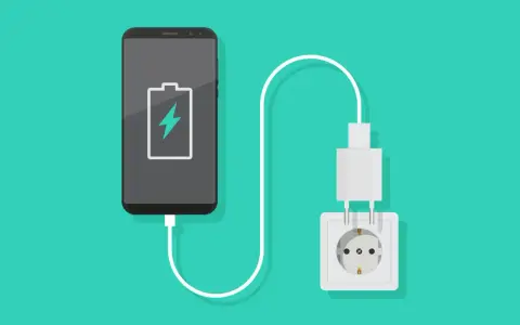 En smartphone med lågt batteri laddas via ett vägguttag.