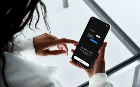 En person håller en smartphone som visar en chattapp. Enkel design för att skapa sms grupp iphone och android.