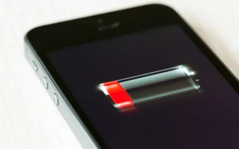 En iPhone med låg batterinivå. Snart slut på samtalstid.