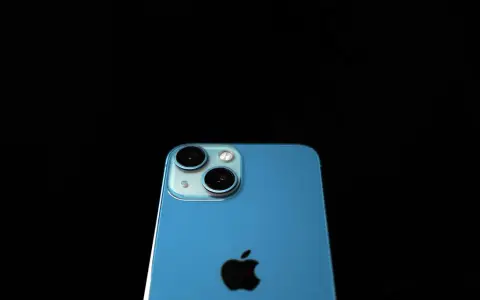 Blå iPhone med dubbla kameror och Apple-logga. Denna apple a16-enhet är redo att fånga dina minnen.