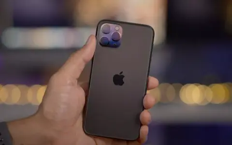 En hand håller en mörk iPhone 11 Pro med sin imponerande trippelkamera.