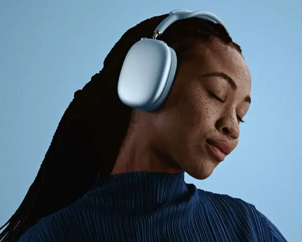En kvinna med slutna ögon njuter av ljudet från sina ljusblå AirPods Pro Max 2.