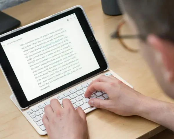 Person skriver på ett iPad-tangentbord. En text om "Zoku Round Pop Molds" visas på skärmen, vilket tyder på ett iPad-tangentbordstest.