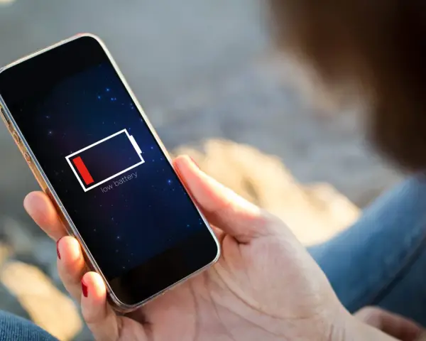 En person håller en mobil med lågt batteri. Kanske 5G drar mer batteri än väntat.