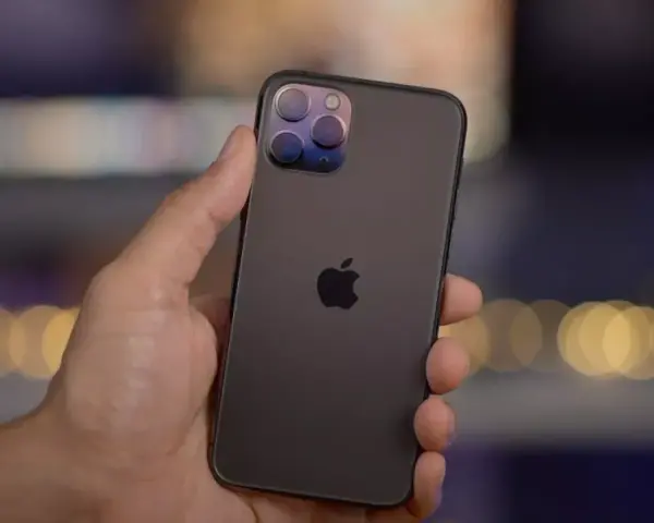En hand håller en mörk iPhone 11 Pro med sin imponerande trippelkamera.