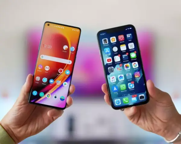 Två händer håller upp varsin smartphone. Den ena visar en Android-telefon, den andra en iPhone. Kanske dags att flytta till iOS?