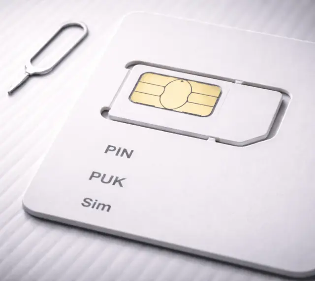 SIM-kort med PIN- och PUK-kod. Ett verktyg för att ta ut SIM-kortet ligger bredvid.
