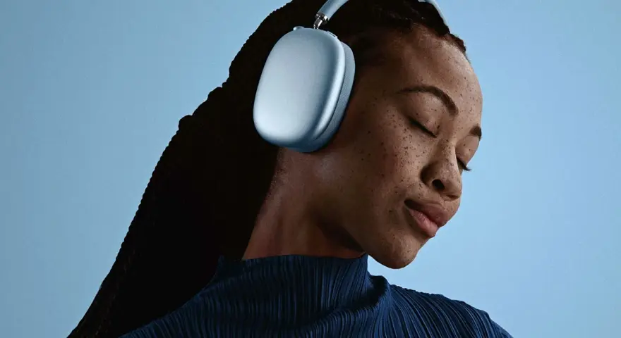En kvinna med slutna ögon njuter av ljudet från sina ljusblå AirPods Pro Max 2.