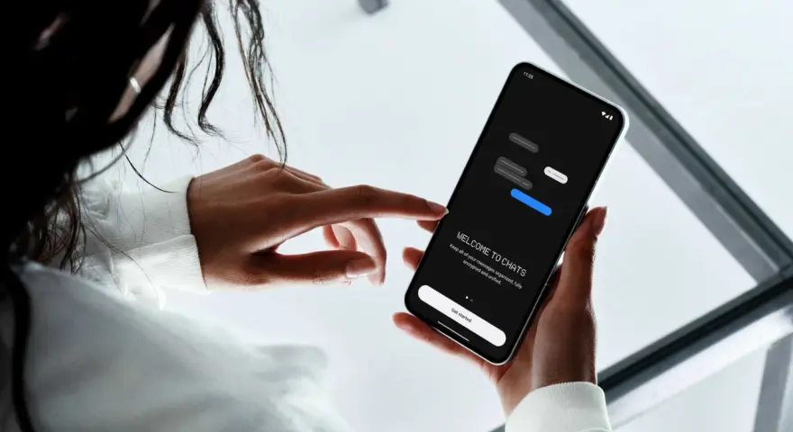 En person håller en smartphone som visar en chattapp. Enkel design för att skapa sms grupp iphone och android.