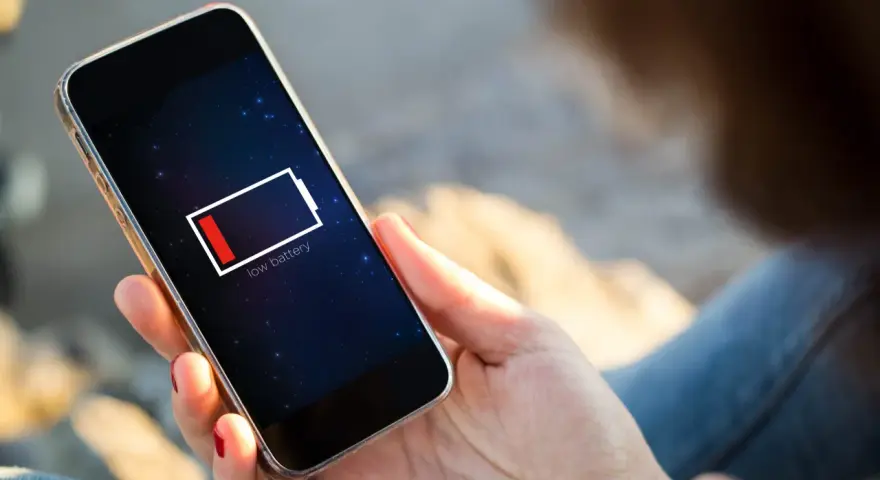 En person håller en mobil med lågt batteri. Kanske 5G drar mer batteri än väntat.