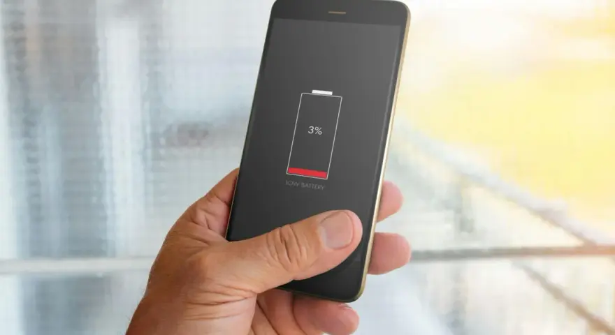 En hand håller en mobil med lågt batteri (3%). Dags att kolla vilka appar som drar mest batteri.