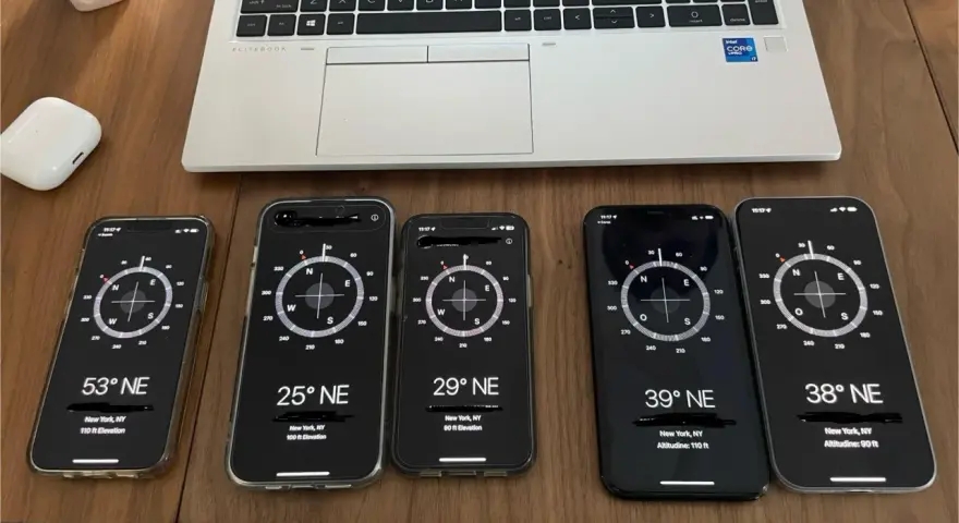 Fem iPhones visar kompass-appar. En laptop och AirPods ligger bredvid.