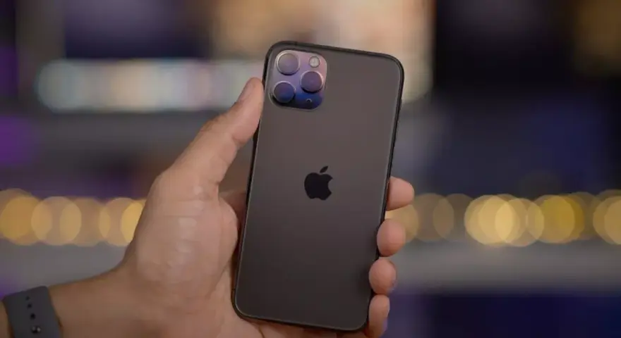 En hand håller en mörk iPhone 11 Pro med sin imponerande trippelkamera.