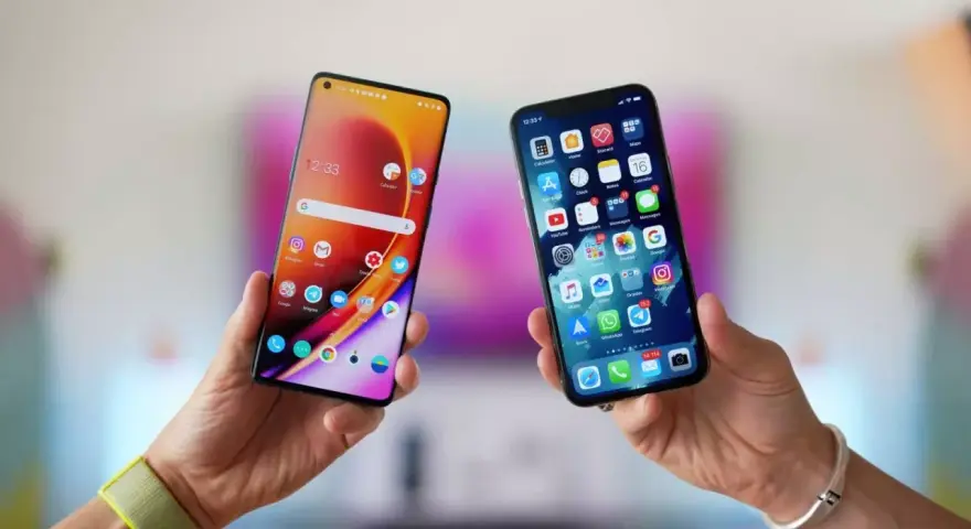 Två händer håller upp varsin smartphone. Den ena visar en Android-telefon, den andra en iPhone. Kanske dags att flytta till iOS?