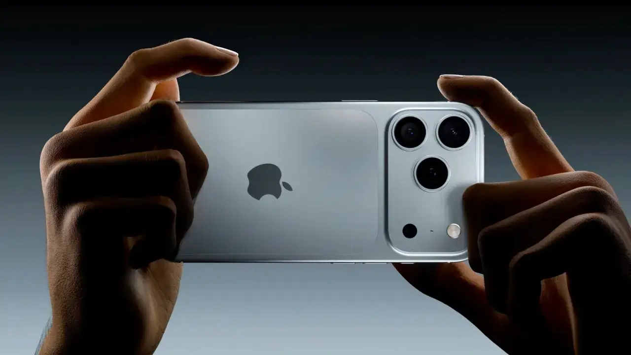Händer håller en iPhone 11 Pro i liggande läge, med fokus på den avancerade kameran.