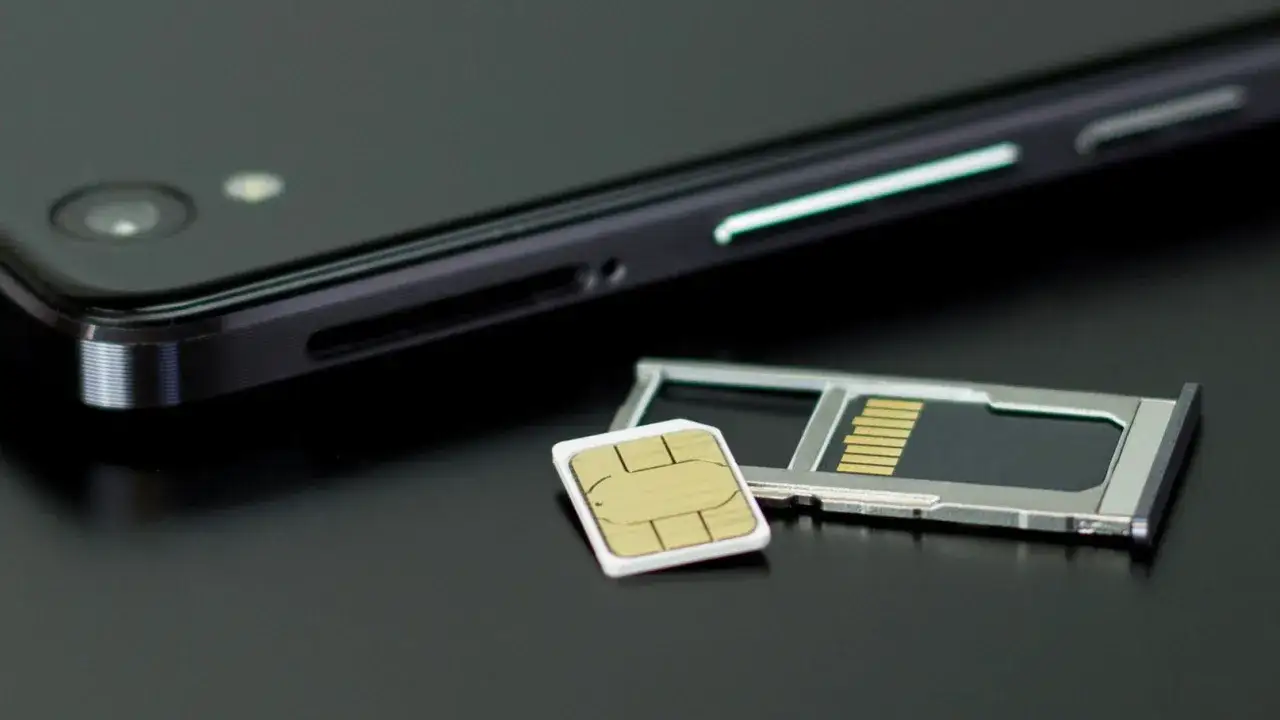En mobiltelefon och ett SIM-kort bredvid SIM-kortsh&aring;llaren. Kanske dags att byta SIM-kort f&ouml;r att kunna ringa utan simkort?