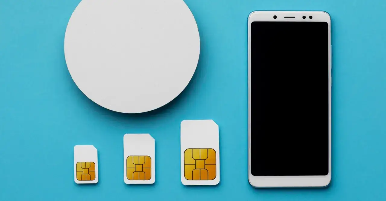 Tre SIM-kort i olika storlekar, från minsta nano sim kort till största, bredvid en smartphone.