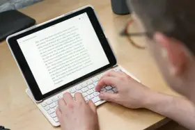 Person skriver på ett iPad-tangentbord. En text om "Zoku Round Pop Molds" visas på skärmen, vilket tyder på ett iPad-tangentbordstest.