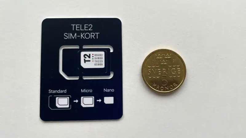 Ett Tele2 SIM-kort med utbrytbara delar för olika storlekar. Bredvid ligger en femkronorsmynt. Frågan om man kan ha två simkort med samma nummer är relevant för att hantera flera enheter.